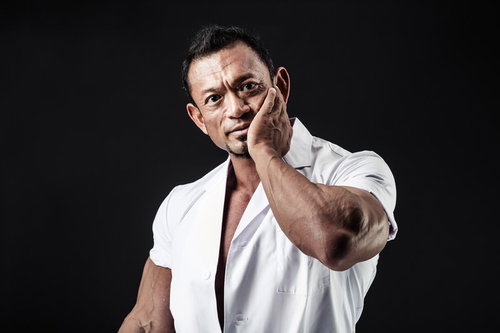 歯科医の虫歯ポーズを決めるボディビルダー