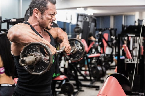 バーベルで大胸筋に負荷をかけるボディビルダー