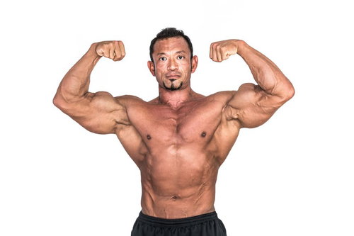 上腕二頭筋の力強さをアピールするボディビルダーの肉体