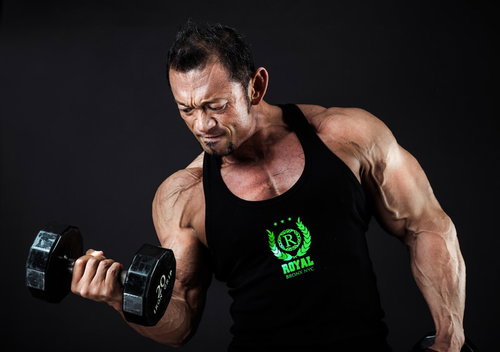 ダンベルでパンプアップするボディビルダー