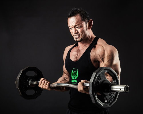 バーベルカールで鍛える男性ボディビルダー