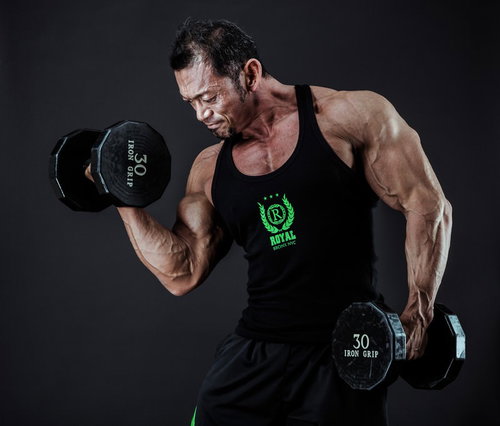 30ポンドのダンベルで上腕二頭筋を鍛えるボディビルダー