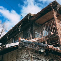 人に忘れられて朽ちていく木造廃屋と時間の経過の写真