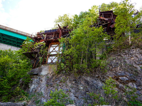 草木が生い茂る北海道の廃採石場と錆びた設備