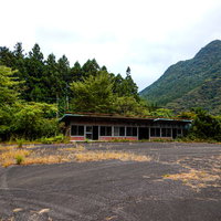 緑豊かな山間部に佇む廃墟と化したドライブインの写真