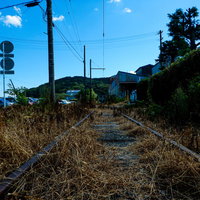 青い空と廃線のレール - 錆びたレールと枕木が続く廃線跡の写真