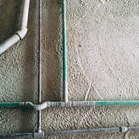 建築中のマンションの壁と細い配管が交錯する構造の写真