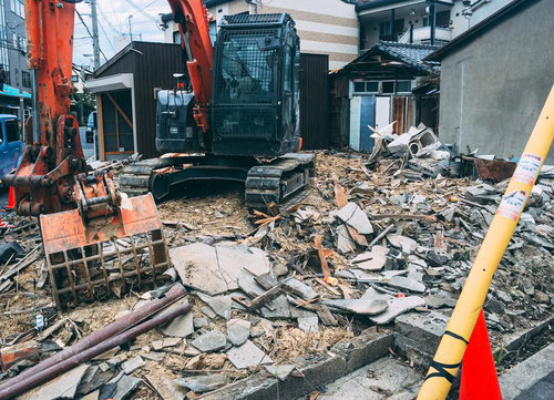解体された瓦礫の山とオレンジ色のショベルカー