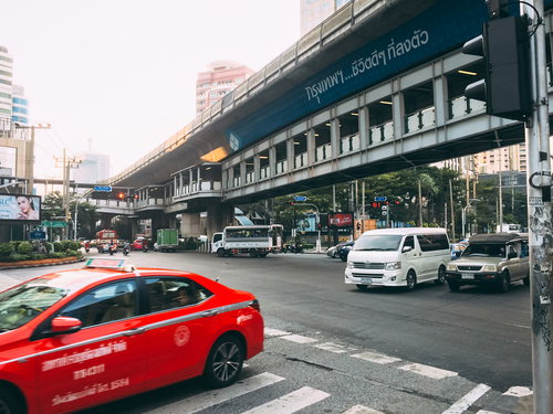 車が行き交うバンコクの交差点の都市交通風景