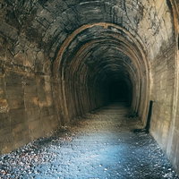 先が見えない古トンネルの内部（JR福知山線廃線敷）の写真