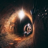 奥から巨大なワニが襲ってきそうな湿ったトンネル内（湊川隧道）の写真