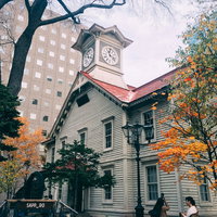 紅葉に挟まれた札幌市時計台（旧札幌農学校演舞場）の秋景色の写真