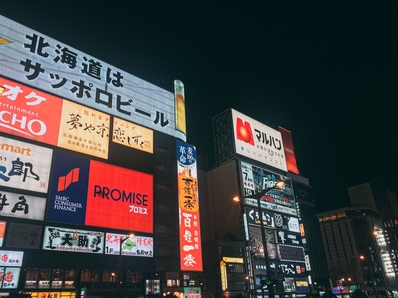 色とりどりのネオンサインが光る夜のすすきの歓楽街の風景