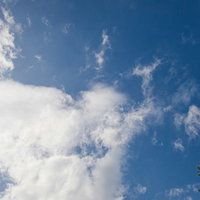 真っ青な快晴の空にぽっかり浮かぶ白い雲の風景の写真