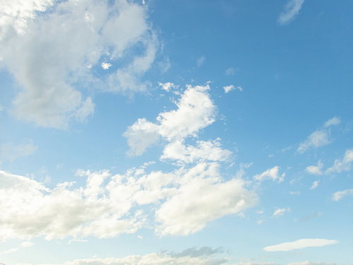 澄んだ水色空にぽっかり浮かぶ白い雲の晴天風景