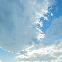 日が雲に隠れる青空と白い雲が広がる爽やかな空景色の写真