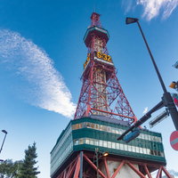 見上げたさっぽろテレビ塔と青空、赤白の鉄塔と白い雲の写真