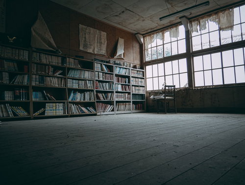 廃校の教室に残された本棚と古びた窓