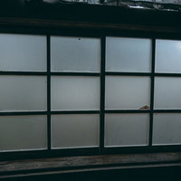 風がふくとガタガタ鳴る廃墟のすりガラス窓の写真