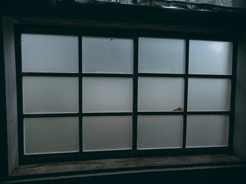 風がふくとガタガタ鳴る廃墟のすりガラス窓