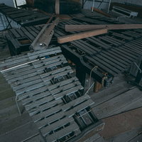 廃校の音楽室に置かれたくたびれた鉄琴と散らばったバチの写真