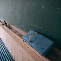 廃校の教室に置かれた古い黒板消しと黒板の風景の写真