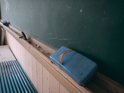 廃校の教室に置かれた古い黒板消しと黒板の風景