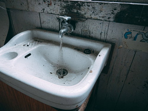 水が流れることはもうない廃校の古い蛇口と洗面台