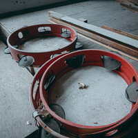 廃校に取り残された古びたタンバリン、窓辺に劣化した2つの楽器の写真