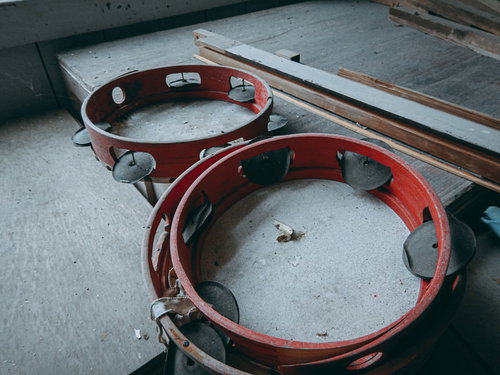 廃校に取り残された古びたタンバリン、窓辺に劣化した2つの楽器