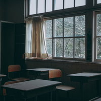 誰もいない廃教室の机と椅子が整然と並ぶ放置された学校教室の写真