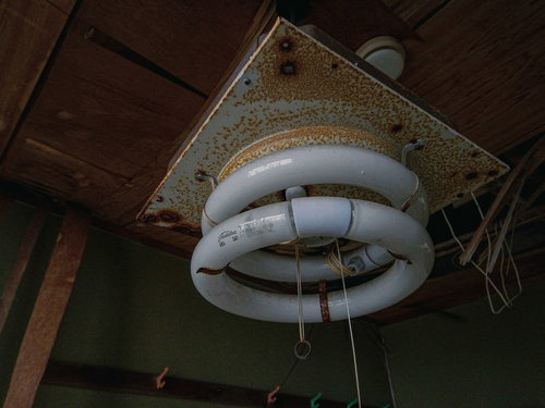 廃墟ホテルの天井に吊り下がる壊れた蛍光灯