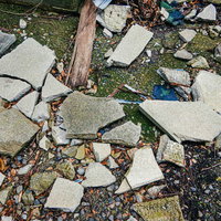 地面に粉々に散らばった石片や木材の破片と瓦礫の写真