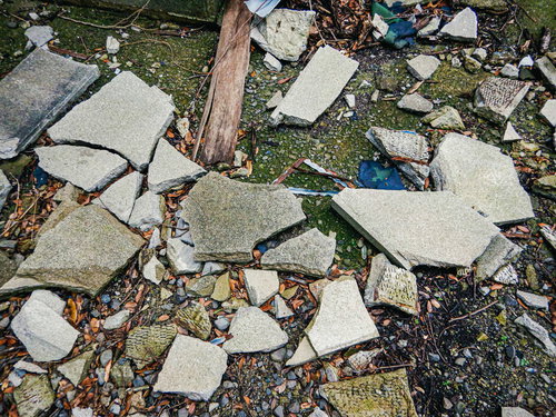 地面に粉々に散らばった石片や木材の破片と瓦礫