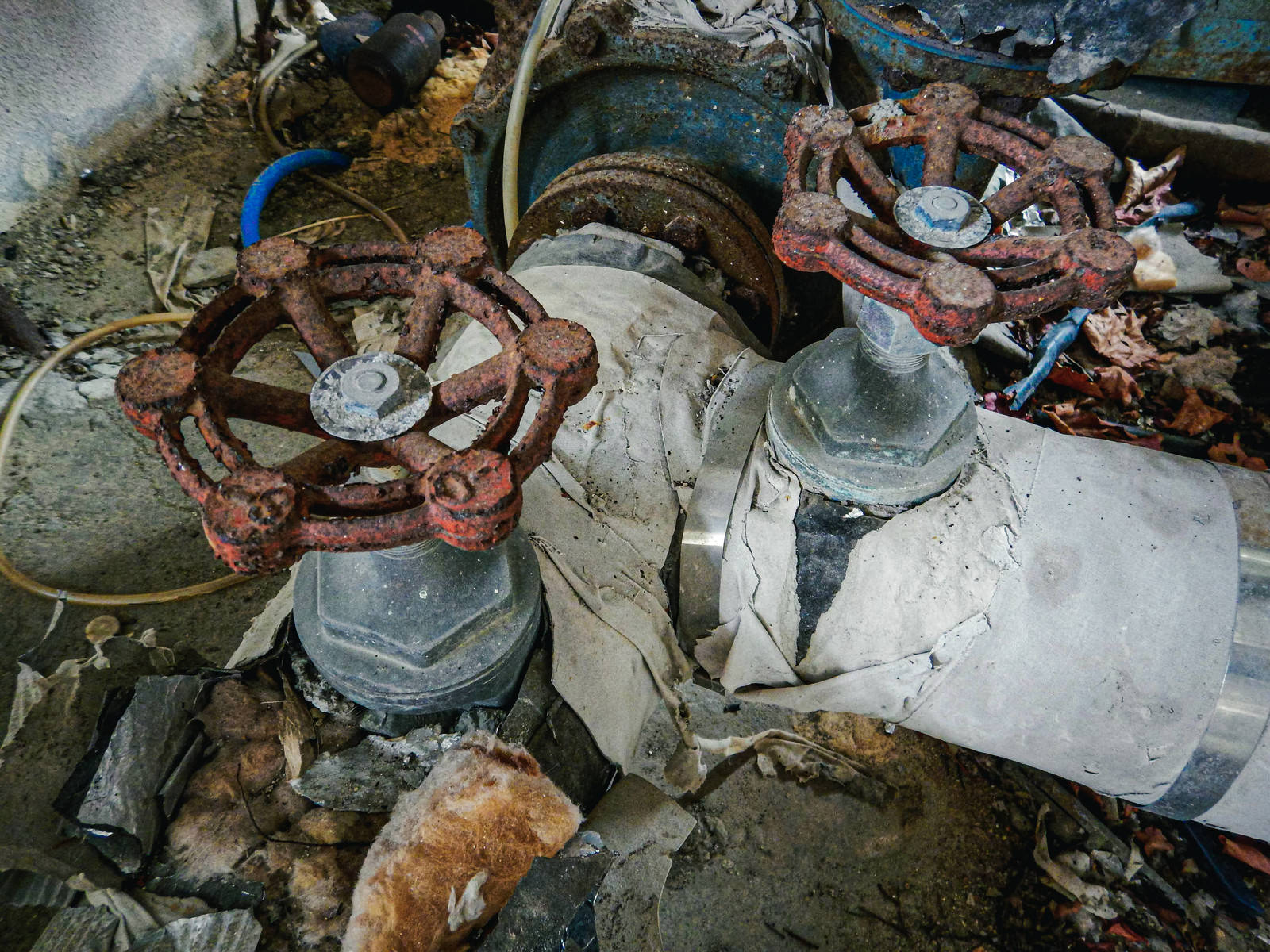 錆びて劣化したバルブと周辺に散らばる瓦礫