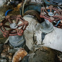 古い建物に残る錆びついたバルブと劣化した配管の写真