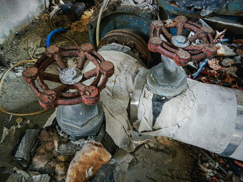 古い建物に残る錆びついたバルブと劣化した配管