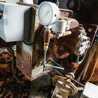 廃墟ホテルの錆びた循環装置のような機器と配管設備の写真