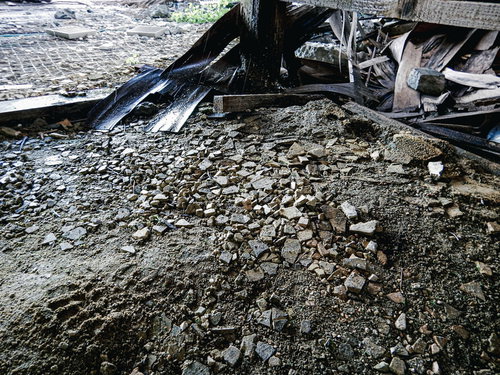 剥がれて散らばる床下コンクリートと瓦礫、倒壊した廃墟の地面