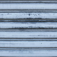 錆と汚れが目立つ傷ついたシャッターのテクスチャーの写真