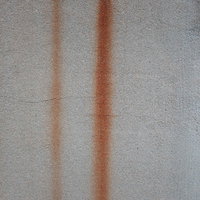 錆が流れ落ちるコンクリート壁の劣化跡と経年変化の写真