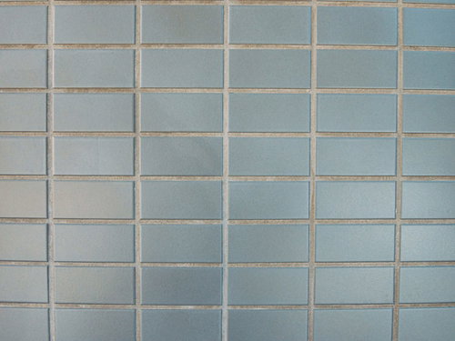 昭和マンションの外壁に並ぶ淡いブルーグレーのタイル