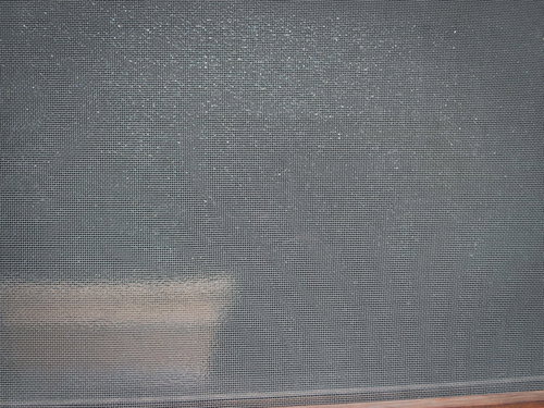 グレーに汚れた網戸のテクスチャー、経年劣化した細かいメッシュ状の網目