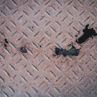 錆びて腐食した穴が空いた金属の足場の写真