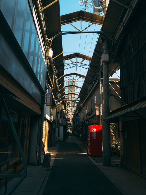 夕暮れ時の商店街のアーケード通路に差し込む西日