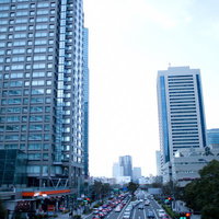車が行き交うみなとみらいの幹線道路と周辺のビル群の写真