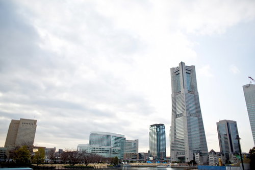 青空の下にランドマークタワーがそびえるみなとみらいの遠景