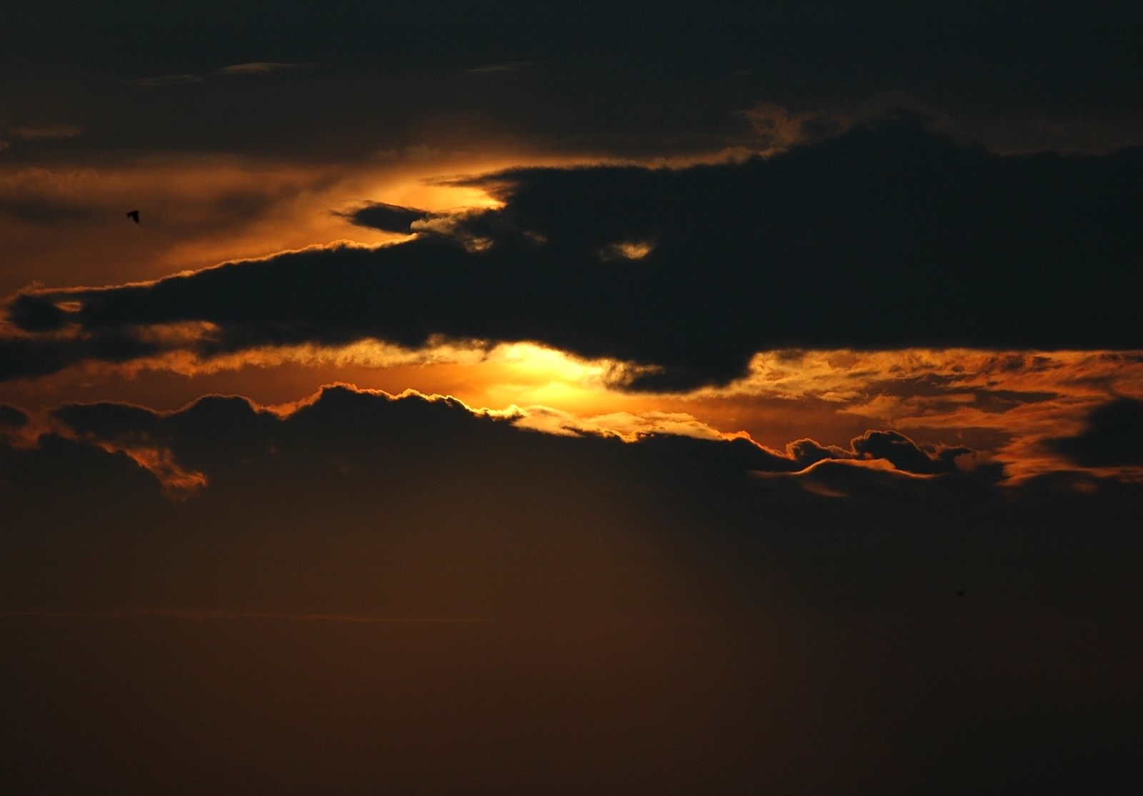 雲の切れ間から光が差し込む夕焼け空