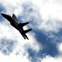 岐阜基地の上空で雲を分けて飛ぶF-2戦闘機の迫力ある姿の写真