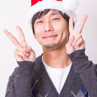 サンタ帽でシングルベルでも超ハッピーに両手を広げる男性の写真